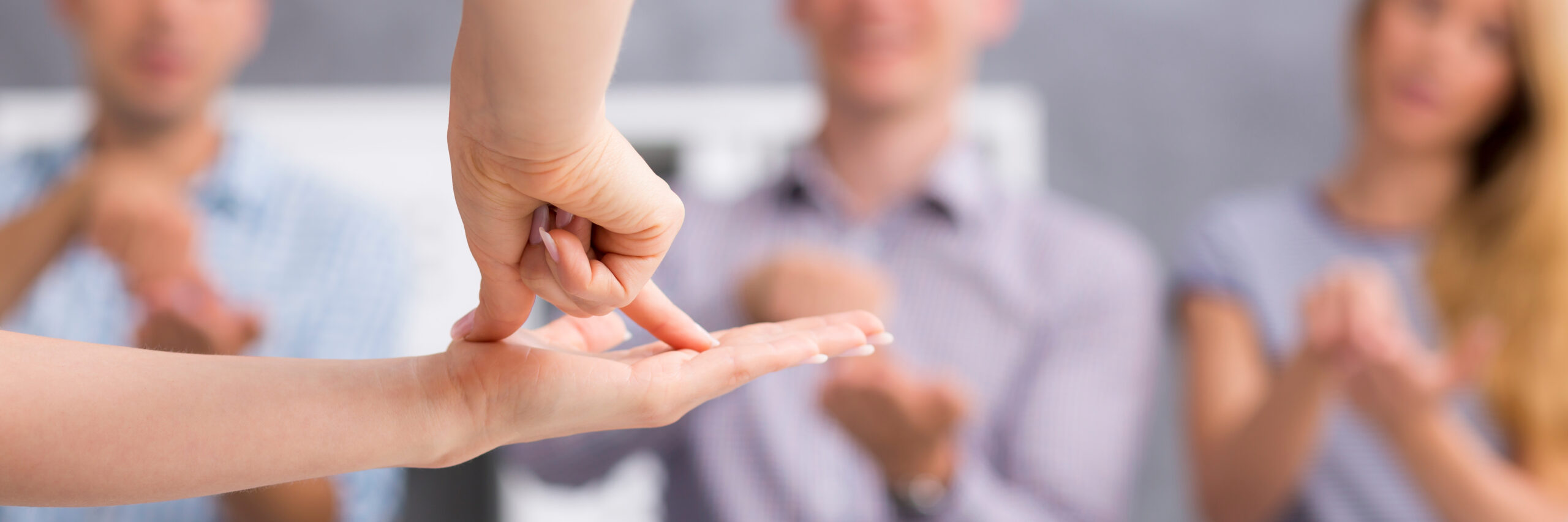 Close up of a person showing the word "flat" using sign language