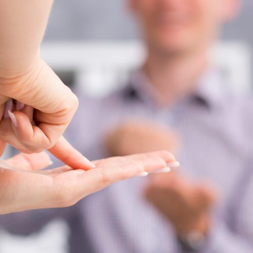 Close up of a person showing the word "flat" using sign language